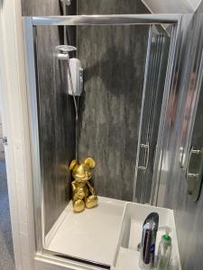 a gold teddy bear sitting on a sink in a shower at 3 Bedrooms and 2 bathrooms with Double drive in Cleethorpes