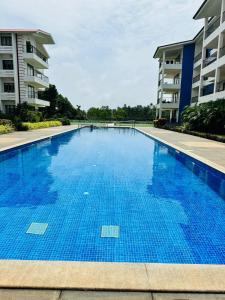 una gran piscina azul junto a un edificio en 03-JenVin Luxury Homes - Garden view 2bed Apartment North Goa en Old Goa