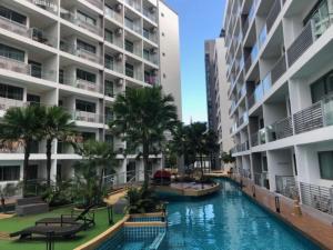 a swimming pool in the middle of a building with palm trees at Laguna Beach Resort 1 by BPS in Jomtien Beach