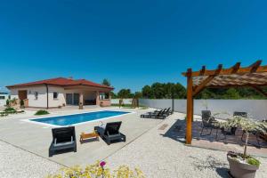 a backyard with a pool and chairs and a pergola at 4* Villa First Hill with heated pool, Zaton in Zaton