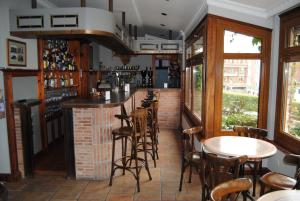 eine Bar in einem Restaurant mit Tischen und Stühlen in der Unterkunft Hotel Hoya in Noja