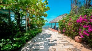 a path leading to a beach with flowers at An Hoa Residence in Long Hai