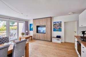 a kitchen and living room with a table and a television at Apartmenthaus Emily by POLY Hohwacht in Hohwacht