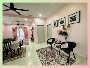- une salle à manger et un salon avec une table et des chaises dans l'établissement CassaNeyna Homestay Kuantan, à Kuantan