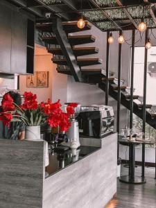 巴吞他尼的住宿－Campagne Hotel and Residence - SHA Plus，柜台和楼梯上种有红色鲜花的厨房