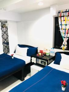 two beds in a room with blue and white at Manila Lounge in Hong Kong