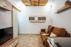Una sala de estar con un sofá y un televisor. en APARTAMENTO BERROCALA, en Cáceres