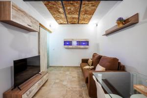 Una sala de estar con un sofá y un televisor de pantalla plana. en APARTAMENTO BERROCALA, en Cáceres