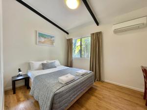 een slaapkamer met een bed met twee handdoeken erop bij Yongala Lodge by The Strand in Townsville