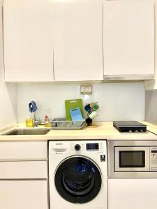 a kitchen with a washing machine and a sink at 2 BR with city view near Subway in central in Singapore