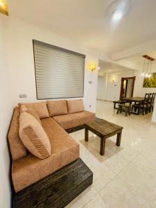 sala de estar con sofá marrón y mesa en Rusty Bunk Villa en Kandy