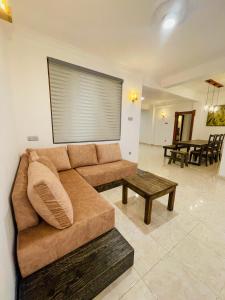 a living room with a brown couch and a table at Rusty Bunk Villa in Kandy