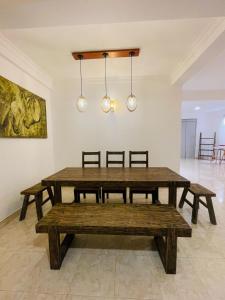 a dining room with a wooden table and benches at Rusty Bunk Villa in Kandy