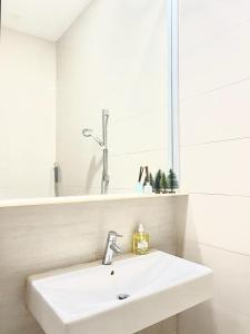 a white bathroom with a sink and a mirror at 2 BR with city view near Subway in central in Singapore