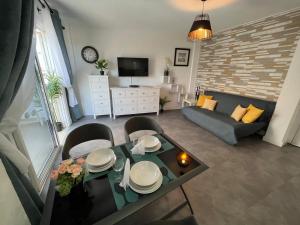 een woonkamer met een tafel en een bank bij Malibu Park Apartments Sol in Adeje