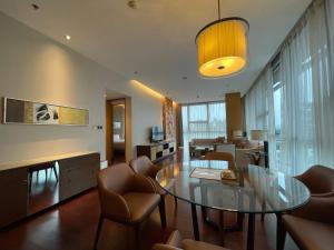 uma sala de estar com uma mesa de vidro e cadeiras em The OCT Harbour, Shenzhen - Marriott Executive Apartments em Shenzhen