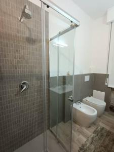 uma casa de banho com uma cabina de duche em vidro e um WC. em Appartamento Violet - Parma em Parma