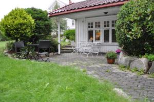 a house with a patio with a table and chairs at Seaside Comfort with Terrace - Business and Leisure Friendly in Tønsberg