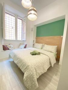 a bedroom with a large bed and two windows at Loft Torlonia in Rome