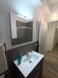 uma casa de banho com um lavatório branco e um espelho. em Appartamento Violet - Parma em Parma