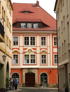 a large building with a red roof in a street at Stadtpalais Königssuite maximal 2 Personen und 1 Kleinkind in Bautzen