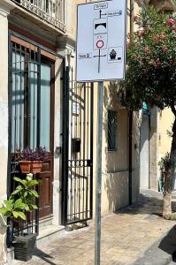 um sinal branco numa calçada em frente a um edifício em Ortigia Loft Via Malta, 22 em Siracusa