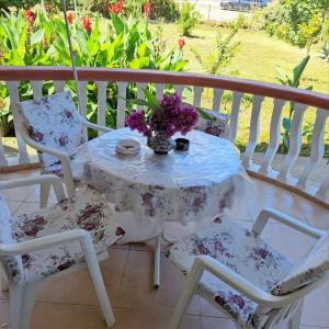 a table with a vase of flowers on a balcony at Montenegro Smile in Dobra Voda