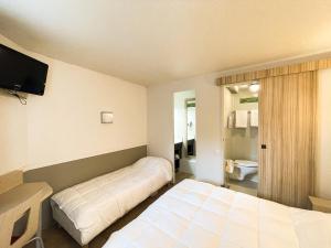 a hotel room with two beds and a television at Hotel du Parc - Chantepie in Chantepie