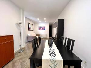 a dining room with a black table and chairs at Hermoso piso en Chamberi in Madrid