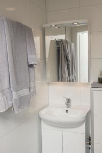 y baño con lavabo, espejo y toallas. en Cosy modern apartment for up to 4 ! en Reikiavik