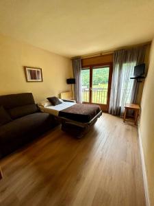 sala de estar con cama y sofá en Apartamentos Turisticos Poblado en Arinsal