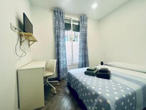 1 dormitorio con cama, escritorio y ventana en Hermoso piso en Chamberi, en Madrid