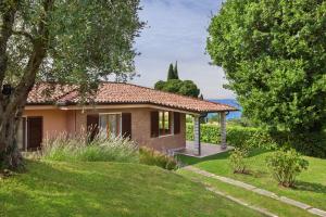 une maison avec un jardin et un arbre dans l'établissement Villa Irene In Bardolino, à Bardolino