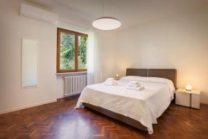 a bedroom with a large white bed and a window at Villa Irene In Bardolino in Bardolino