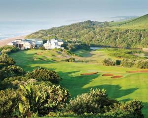 an aerial view of a golf course with a resort and the ocean at Refined 3 Bedroom Apartment Princes Grant in Blythedale