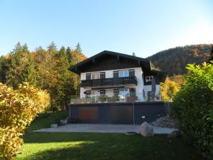 a large house with a garage in a yard at Ferienwohnung Christine am Weissenbach in Strobl