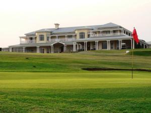 a large house on a golf course with a green at Refined 3 Bedroom Apartment Princes Grant in Blythedale