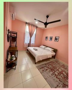 um quarto com uma cama e uma ventoinha de tecto em CassaNeyna Homestay Kuantan em Kuantan
