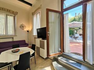uma sala de estar com uma mesa e uma grande janela em La mia limonaia sui colli, garden, parking, fit for bike ! em Florença