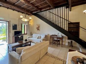 ein Wohnzimmer mit einem Sofa und einer Treppe in der Unterkunft Villa Faye in Vryses