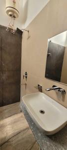 bagno con lavandino bianco e specchio di SPOT ON Hotel Sainik Inn a Nalmatha
