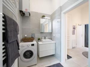 een wasruimte met een wasmachine en een wastafel bij Stylish City Center Apartment in Wenen