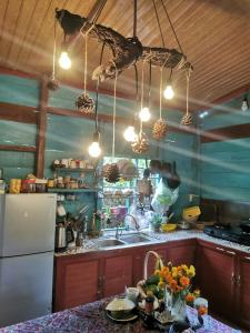 a kitchen with a counter with a sink and a refrigerator at Lily's Stone Garden bungalow in Buôn Bu Djri +28 photos