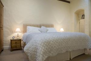 a bedroom with a large bed and two lamps at Ballachrink Farm Cottages in Laxey