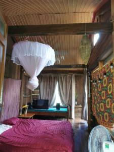 Cette chambre comprend un lit avec des draps violets et un lustre. dans l'établissement Lily's Stone Garden, 