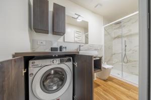 a kitchen with a washing machine in a bathroom at Easylife - Moderno rifugio a due passi dal duomo in Milan