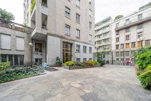 a courtyard of a building with some plants and buildings at Easylife - Moderno rifugio a due passi dal duomo in Milan
