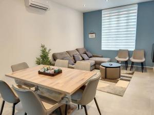 a living room with a table and a couch at Maison proche centre ville clim jardin wifi 8 personnes in Amiens