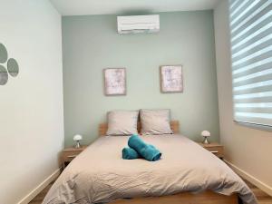 ein Schlafzimmer mit einem Bett mit einem blauen Kissen darauf in der Unterkunft Maison proche centre ville clim jardin wifi 8 personnes in Amiens