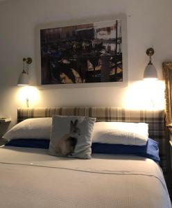 The Guest Suite, Buttsfield Lane. في East Hoathly: كلب يجلس على وسادة على سرير